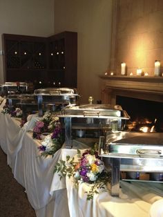 the buffet table is set up with flowers and candles