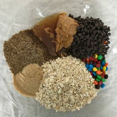 an assortment of cereal, peanut butter, and chocolate on a clear plastic plate with white paper