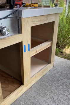 an outdoor kitchen built into the side of a house with blue tape taped to it