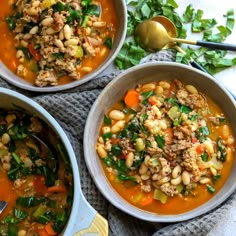 three bowls filled with soup on top of a table