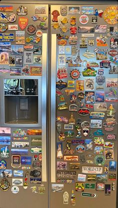 a refrigerator covered in lots of magnets and stickers on it's side