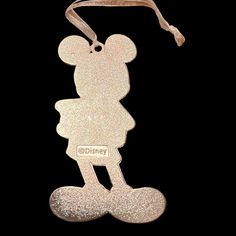 a mickey mouse ornament hanging from a ribbon on a black background with the name disney