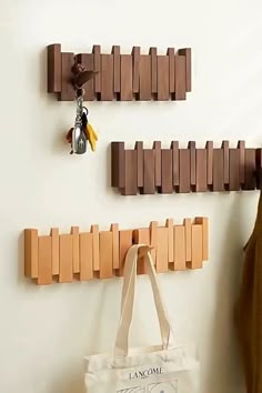 a bag hanging on the wall next to a wooden peg board key holder and coat rack