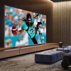 a large television screen with a football player on it's side in a living room