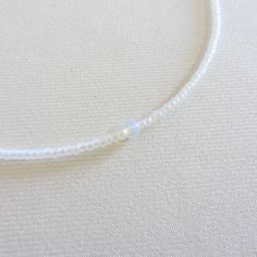 Moonstone beaded necklace, White seed bead necklace, Waterproof necklace, Tiny simple choker, Stainless steel necklace There are two clasp options, one is a stainless steel clasp and chain, the second option the clasp and chain are made of brass with 14k gold plating so the necklace will not lose its look over time! Choker is 13 inches with a 2 inches adjustable extender chain. 15 inches full length. The necklace is made with 10/0 size Czech seed beads. Measure the length of your neck with a measuring tape or you can use any thread, rope, or cable for telephone and after apply the measurements to a regular ruler. Adjustable Single Strand Crystal Choker Necklace, Adjustable Single Strand Crystal Choker, Minimalist Single Strand Beaded Necklace, Dainty White Crystal Necklaces, Minimalist Adjustable Hypoallergenic Necklace, Adjustable Hypoallergenic Minimalist Necklace, Adjustable Moonstone Beaded Necklace For Gift, Minimalist Gemstone Beads Choker, Dainty Adjustable Crystal Necklaces With Round Beads