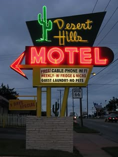 the neon sign for desert hills motel is lit up in red, green and yellow