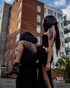 a man and woman standing next to each other in front of a tall building