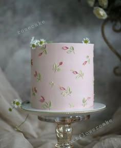 a pink cake with white flowers on it