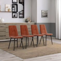 four orange chairs sitting on top of a rug