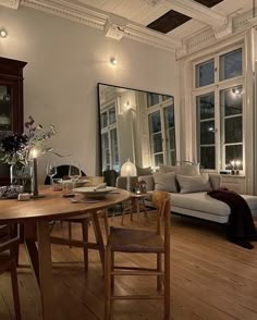 a living room filled with furniture and windows next to a wooden floored flooring