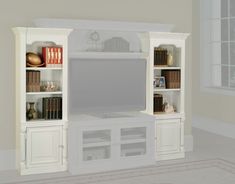 a white entertainment center with bookshelves and a flat screen tv