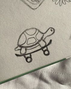 a drawing of a turtle on top of a sheet of paper next to a flower