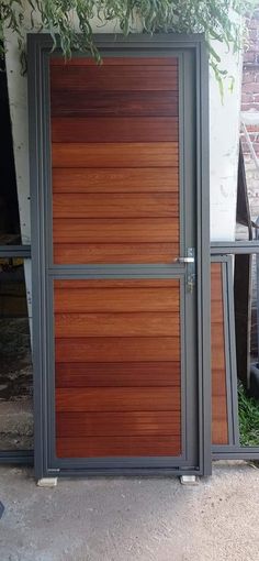 a large wooden door sitting next to a brick building with metal bars on the sides