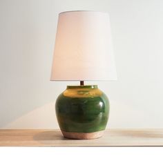 a green ceramic lamp with a white shade