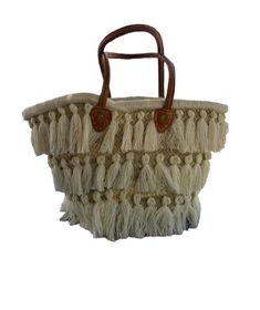 a handbag with fringes and leather handles on it's handle, sitting in front of a white background