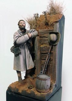 a statue of a man standing next to a barrel