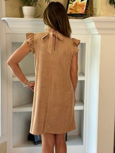 Embrace elegance with our Suede Ruffle Sleeve Dress in Taupe. This chic and sophisticated dress will be your new fall favorite. Whether you're heading to a special event or a casual outing, this dress is up to the job. Pair it with your favorite boots or booties for a complete look. DETAILS Faux Suede Fabric: Soft and luxurious feel in a beautiful taupe color. Ruffle Sleeves: Add a touch of femininity and flair. High Neck Band with Slight Ruffle: Enhances the elegant and refined look. Keyhole an Spring Taupe V-neck Dress, Chic Taupe V-neck Dress, Beige V-neck Mini Dress With Button Closure, Beige Ruffled V-neck Mini Dress, Rayon V-neck Mini Dress With Ruffles, Ruffle Sleeve Dress, Faux Suede Fabric, Favorite Boots, Sophisticated Dress