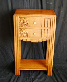 a small wooden table with drawers on it