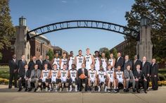 a group of men standing next to each other in front of a sign that says purdue university