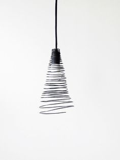 a black and white photo of a light hanging from a wire with wires coming out of it