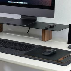 a computer desk with a keyboard, mouse and monitor on it's side table