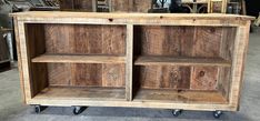 a wooden shelf sitting on wheels in a room