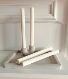 two candles sitting on top of a white tray