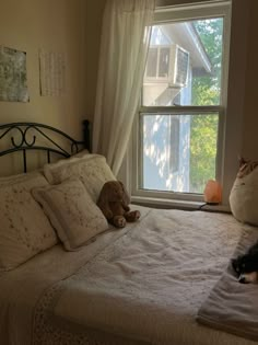 two cats are laying on the bed looking out the window