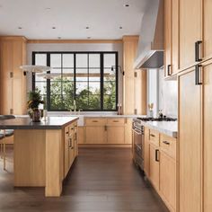 a large kitchen with wooden cabinets and black counter tops, along with an island in the middle