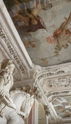 an ornate ceiling with paintings on it and statues in the foreground, along with other art work