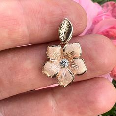 Pua'a (Sparkling Flower) pendant with a Diamond in the center and leaf bail. Approx. 16mm wide. Available in: 14K Yellow Gold w/ .10ct Diamond [PD4-Y10D-V]14K Yellow Gold w/ .12ct Diamond [PD4-Y12D-V]14K Pink Gold w/ .12ct Diamond [PD4-P12D-V] Pictured with 14K Yellow Gold 1.5mm 16'' Rope Chain (RC29). All Sales Final. No returns or exchanges. Chain sold separately. Hawaiian Heirloom Jewelry, Hawaiian Plumeria, Heirloom Jewelry, Band Necklace, Cross Heart, Heirlooms Jewelry, Womens Wedding Bands, Initial Pendant, Flower Heart