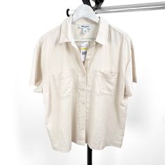 Add A Touch Of Sophistication To Your Wardrobe With This Elegant Nine West Women's Beige Solid Collar Short Sleeve Button Down Blouse, Available In Sizes Medium And Large. Crafted From High-Quality Materials, This Blouse Features A Classic Beige Hue And A Stylish Collar Design, Perfect For Both Casual And Formal Occasions. Whether You're Dressing For The Office Or A Weekend Brunch, This Versatile Blouse Offers Comfort And Style In One Chic Piece. Key Features: Brand: Nine West Gender: Women's Type: Blouse Style: Button Down Color: Beige Sleeve Length: Short Sleeve Closure: Button Down Available Sizes: Medium, Large Elevate Your Look With This Timeless Blouse That Pairs Effortlessly With Je Elegant Summer Shirt With Back Button Closure, Everyday Spring Blouse With Collared Neckline, Spring Everyday Blouse With Collared Neckline, Elegant Tops With Button Closure In Neutral Color, Spring Cream Shirt With Button Closure, Spring Beige Button-up Blouse, Cream Collared Top For Summer, Beige Collared Shirt For Day Out, Collared Beige Shirt For Day Out