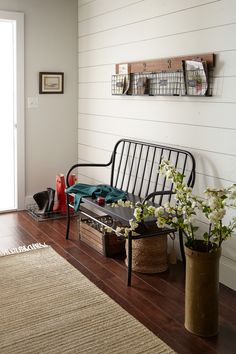 a metal bench sitting on top of a hard wood floor next to a wall mounted shelf