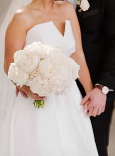 the bride and groom are holding their bouquets