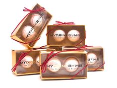 four boxes are wrapped in red string and have white balls on them, with the words mydrin b - me printed on it