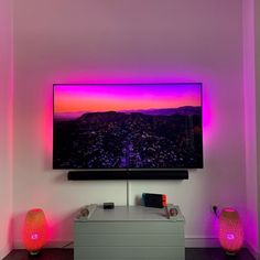 TV and entertainment center surrounded by pink and purple Philips Hue smart lighting. Led Behind Tv Living Rooms, Led Lights Sync To Tv, Led Light Around Tv, Small Smart Tv, Behind Tv Lights, Tv With Lights Behind It, Behind Tv Lighting, Tv Set Up Bedroom Aesthetic, Led Lights On Tv