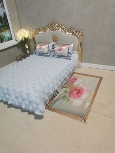 a bedroom with a bed, rug and flowers on the floor in front of it