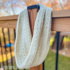 a close up of a wooden rail with a white scarf hanging on it's end