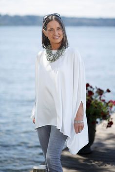 This gorgeous new addition to our Calabria Collection is perfect for a night on the town or dressed down with jeans running errands. Either way you’ll look elegant with classic style. This flowy top is crafted from lightweight viscose fabric for a look that's distinguished yet comfortable. This poncho comes in one size and is 100% viscose. Cheap White Winter Poncho, Luxury Oversized Chic Poncho, Luxury White Tunic, Luxury Flowy Tunic For Women, Luxury Women's Poncho With Scarf, Luxury Tunic Kimono For Women, Luxury Elegant Beach Tunic, Luxury Chic Poncho With Batwing Sleeves, Luxury Chic Poncho For Layering