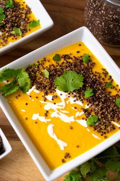 two white bowls filled with soup and garnished with cilantro