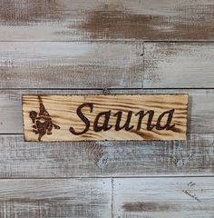 a wooden sign with the word sana written in black ink on wood planks