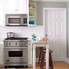 a kitchen with white cabinets and stainless steel appliances