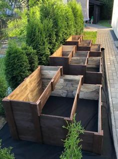 several wooden boxes are lined up on the side of a road in front of some bushes