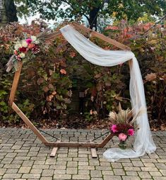 a wedding arch decorated with flowers and greenery