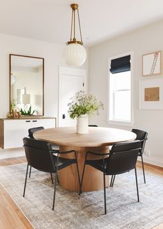 a dining room table surrounded by black chairs