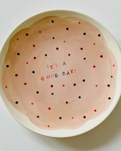 a bowl that says it's a good day with colorful dots on the bottom