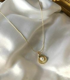 Embrace the elegance of the ocean with this Gold-Plated Pearl Shell Necklace. This elegant piece features a beautifully crafted shell necklace that houses a lustrous pearl. Perfect for beach lovers and those who appreciate the subtle beauty of the sea, this necklace is perfect for both everyday and special occasion wear. The gold-plated chain adds a touch of elegance, making it a timeless addition to your jewelry collection or a thoughtful gift for someone special. Details: * Color: Gold * Material: Gold-plated alloy, imitation pearl * Pendant Size: Approx. 1 cm x 1 cm (shell and pearl) * Chain Length: 45 cm (18 inches) with adjustable extension * Closure: Parrot clasp * Care Instructions: Avoid contact with water, perfume and other chemicals. Store in a dry place when necklace is not in u Subtle Beauty, Luxe Jewelry, Necklace Elegant, Seashell Necklace, Shell Necklace, Shell Jewelry, Book Aesthetics, Pearl Shell, Beach Lovers