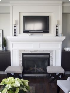 a living room with a fire place and television on the wall above it's mantle