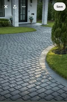 the driveway is made from cobblestones and has a circular design