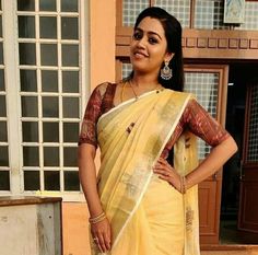 a woman in a yellow sari posing for the camera